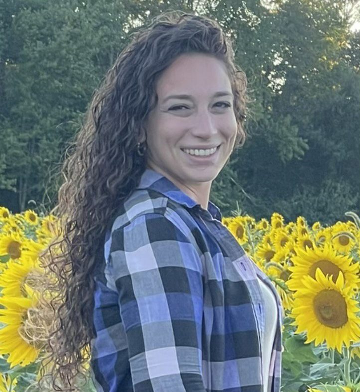 Jacquelyn standing in front of sunflowers